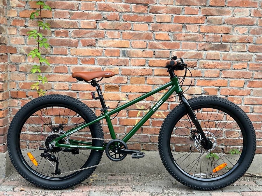 Rocket in green, against a brick wall