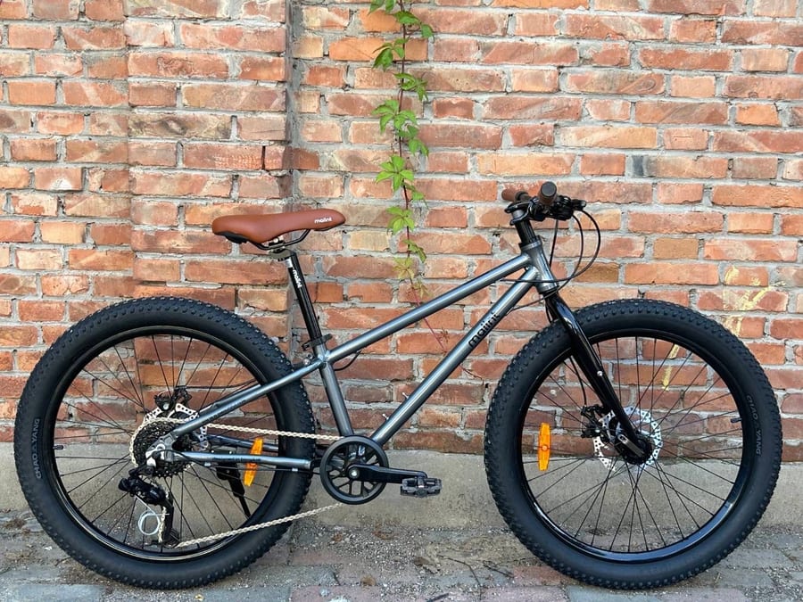 Rocket in grey, against a brick wall