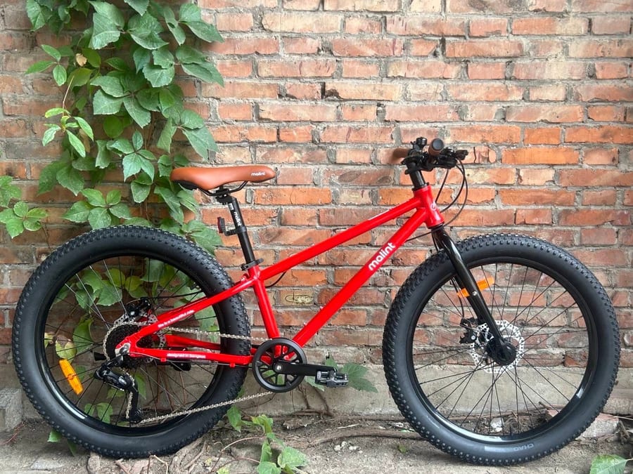 Rocket in red, against a brick wall
